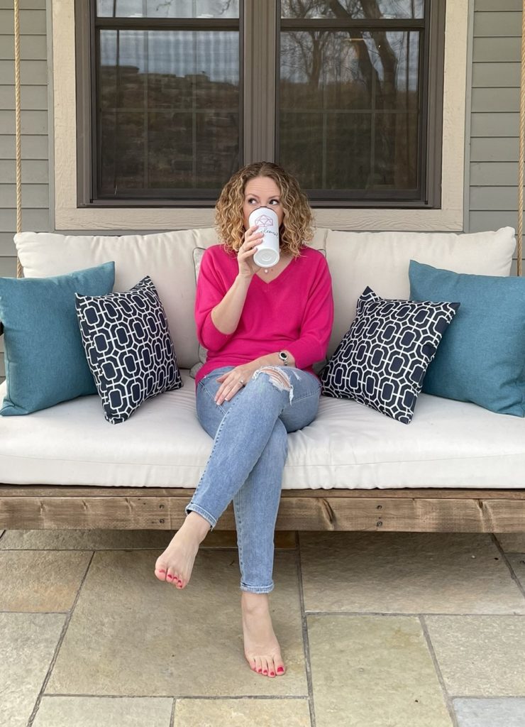 Photo of me sitting on a porch swing, sipping from a mug